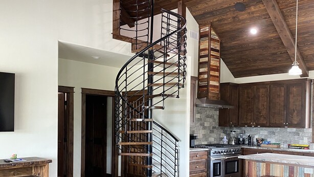 A modern kitchen with a central island, a built-in oven, and a stove. - The River Lodge (Uvalde)