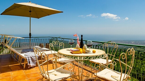 A terrace with a table, chairs, and an umbrella overlooking a scenic view. - Villa Alberto - Country Relax (Puntalazzo)