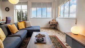 A modern living room with a sofa, coffee table, and a view of the outdoors through large windows. - Villa Alberto - Country Relax (Puntalazzo)