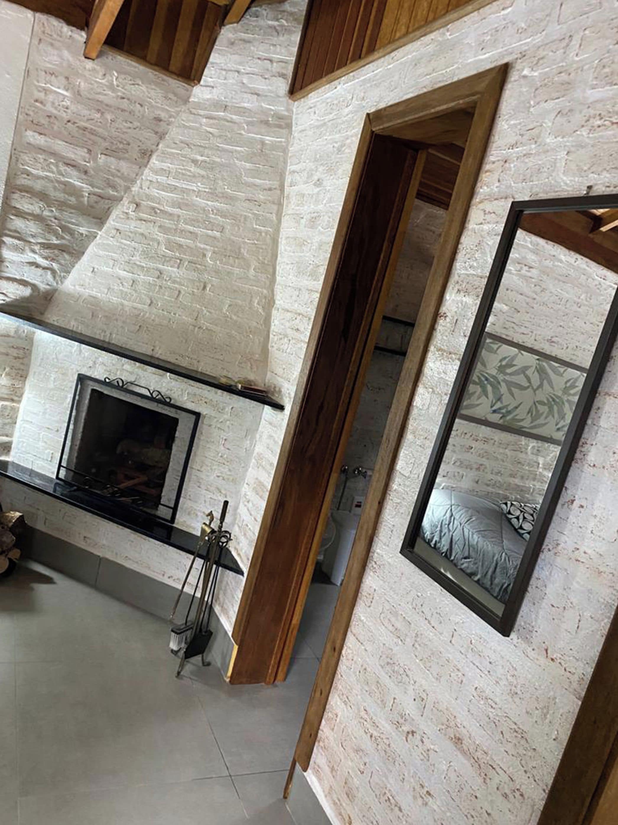 Ein Zimmer mit Kamin, einer Holztür und einer Wand mit Muster.