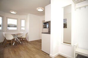 Eine moderne Küche mit Einbauofen und Essbereich mit Tisch und Stühlen.