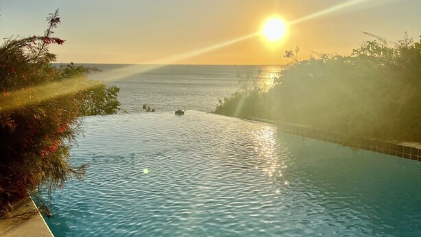 Vista despejada de una piscina con un atardecer de fondo.