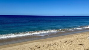Una playa con agua azul cristalina y una orilla arenosa.