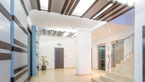 Ein modernes Interieur mit einer Treppe, einer Tür mit der Aufschrift "Entrance" und einem Blumentopf.