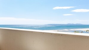 Ein Balkon mit Blick auf das Meer und ferne Berge.
