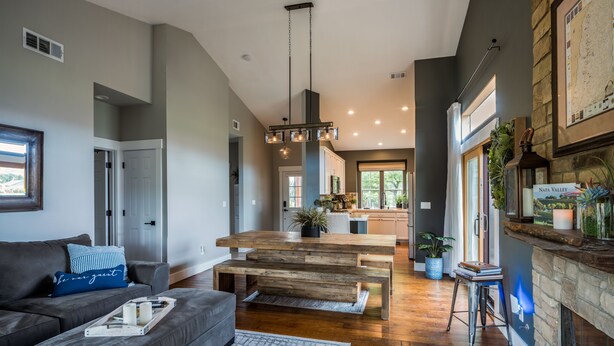 Una sala de estar moderna con un sofá gris, una mesa de centro de madera y una chimenea.