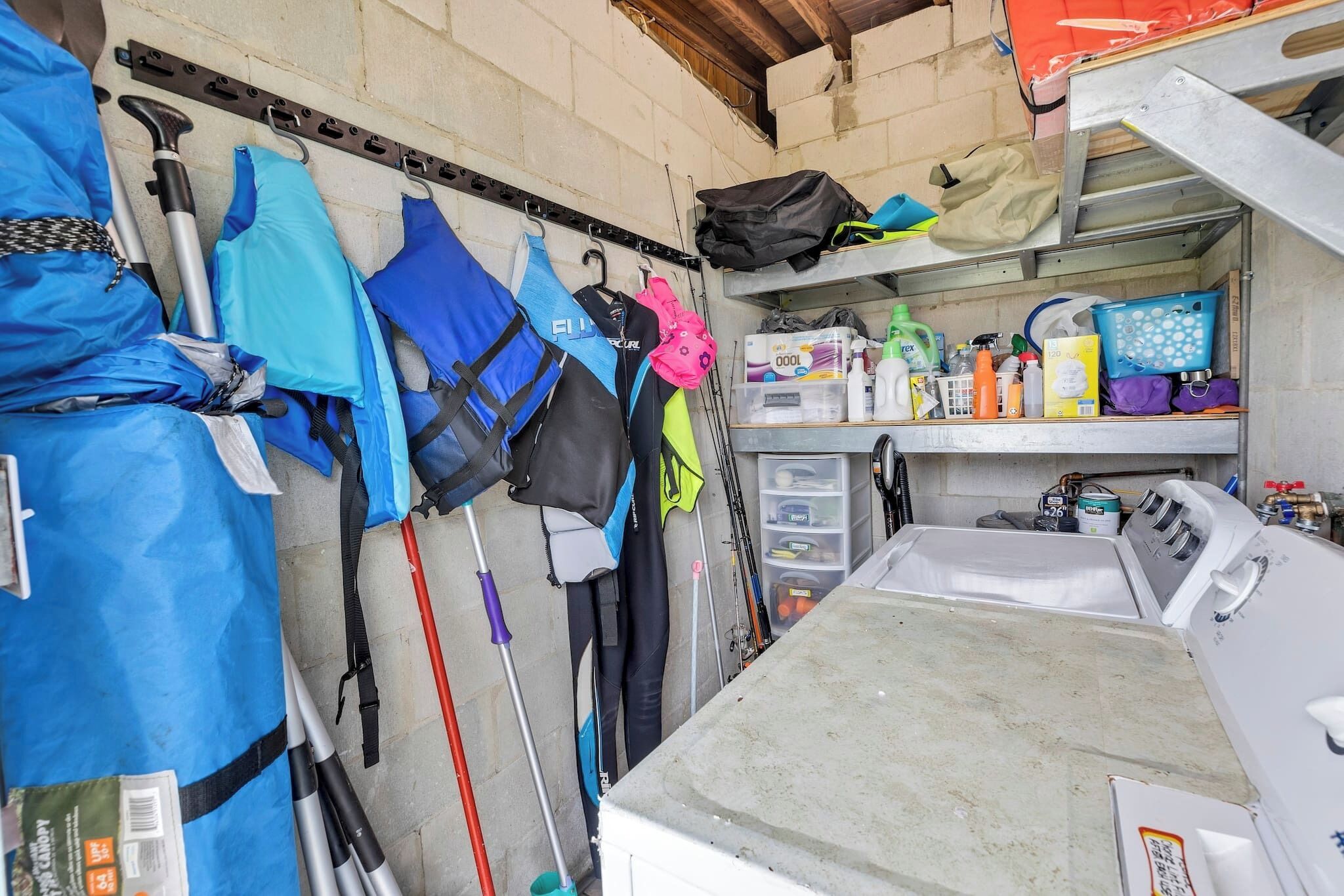 Un espace de rangement contenant divers articles, notamment des sacs, des produits de nettoyage et du matériel.