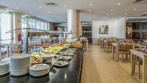 Un buffet avec plusieurs présentoirs de nourriture et des tables où les clients peuvent s’asseoir pour manger.