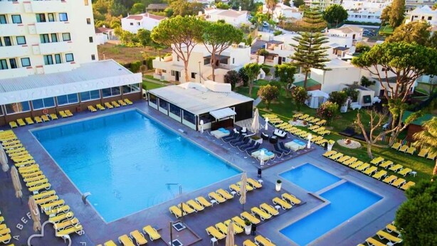Une grande piscine dotée de nombreux transats et d’un espace salon abrité.
