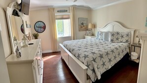 A bedroom with a bed, dresser, ceiling fan, and a window with curtains. - C2 Pet-friendly, 1 BR, 1 BA, sleeps 5 (St. Simons Island)