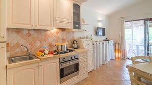 A kitchen with a sink, stove, and countertop with food items. - Dimora di Rosy Pittulongu, Pittulongu, Italy (Pittulongu)