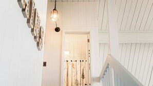 A staircase with a white railing and a wall with framed pictures. - The Little Red Barn w/ Spectacular Views & Less than 1 mile - Blue Ridge Parkway (Hillsville)