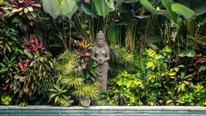 A statue surrounded by lush tropical foliage. - Villa Tirtha Amertha Ubud (Ubud)