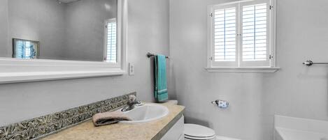 A bathroom with a sink, toilet, and bathtub.