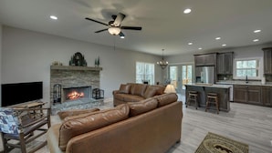 A spacious living room with a leather sofa, a fireplace, and a television. - Blue Heaven, Family vacation near Ocoee River, McCaysville, and Blue Ridge Area (Copperhill)