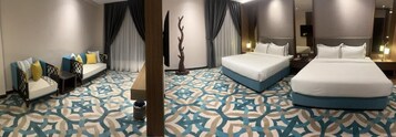 Una habitación de hotel con una cama grande, un sofá y una pequeña mesa.
