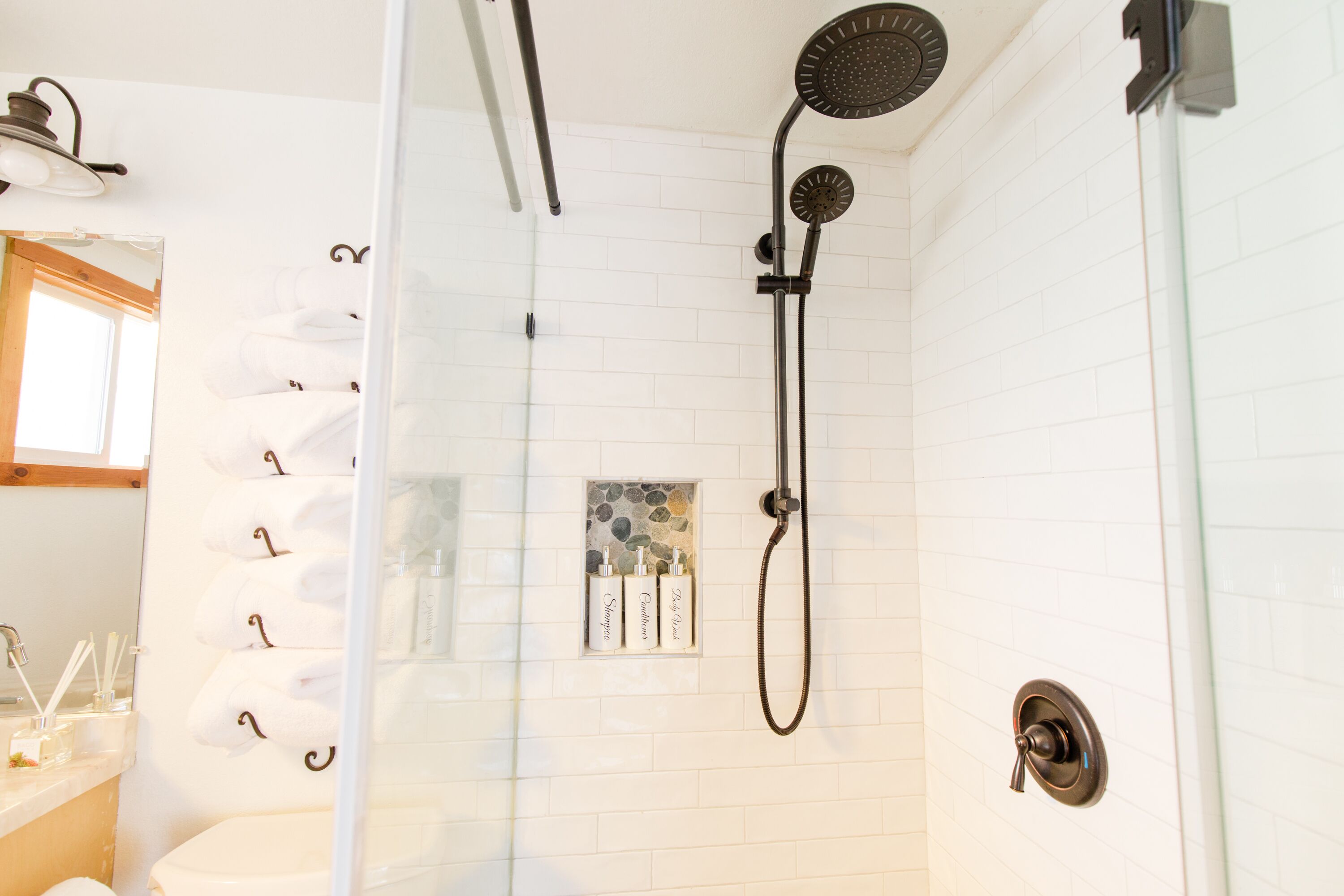 A shower with a handheld showerhead and a wall-mounted faucet.