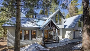 A cabin with a stone-paved entrance, a covered porch, and a garage. - Deer Meadow Cabin @ Shaver Lake (Shaver Lake)