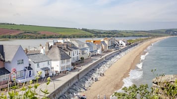 Une ville côtière dotée d’une promenade, de murs en pierre et de bâtiments qui bordent la plage.