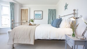 Une chambre à coucher avec un lit, une table de chevet, une lampe et une décoration en forme d’étoile sur le mur.