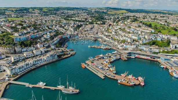 Une ville côtière dotée d’un port de plaisance, d’immeubles résidentiels et d’un pont.