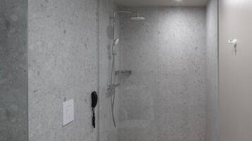 A modern bathroom with a shower, toilet, and sink.