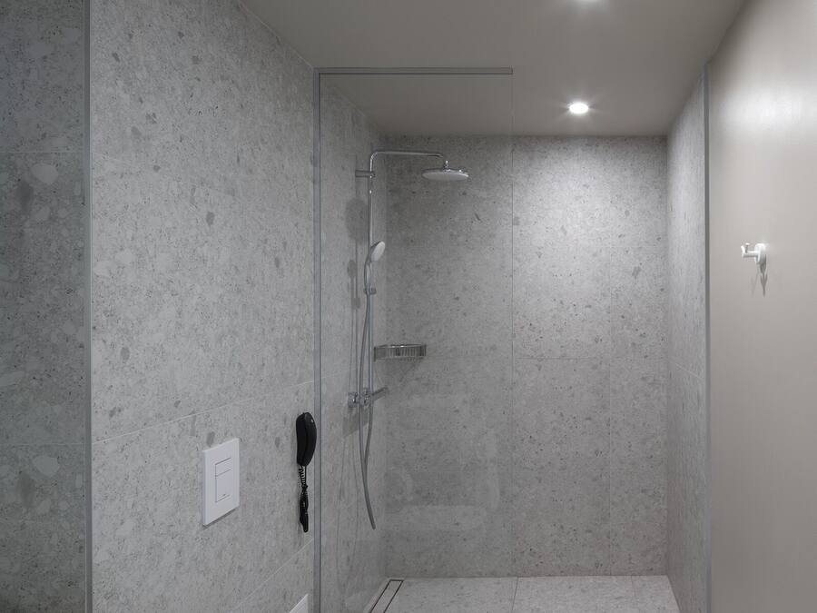 A modern bathroom with a shower, toilet, and sink.