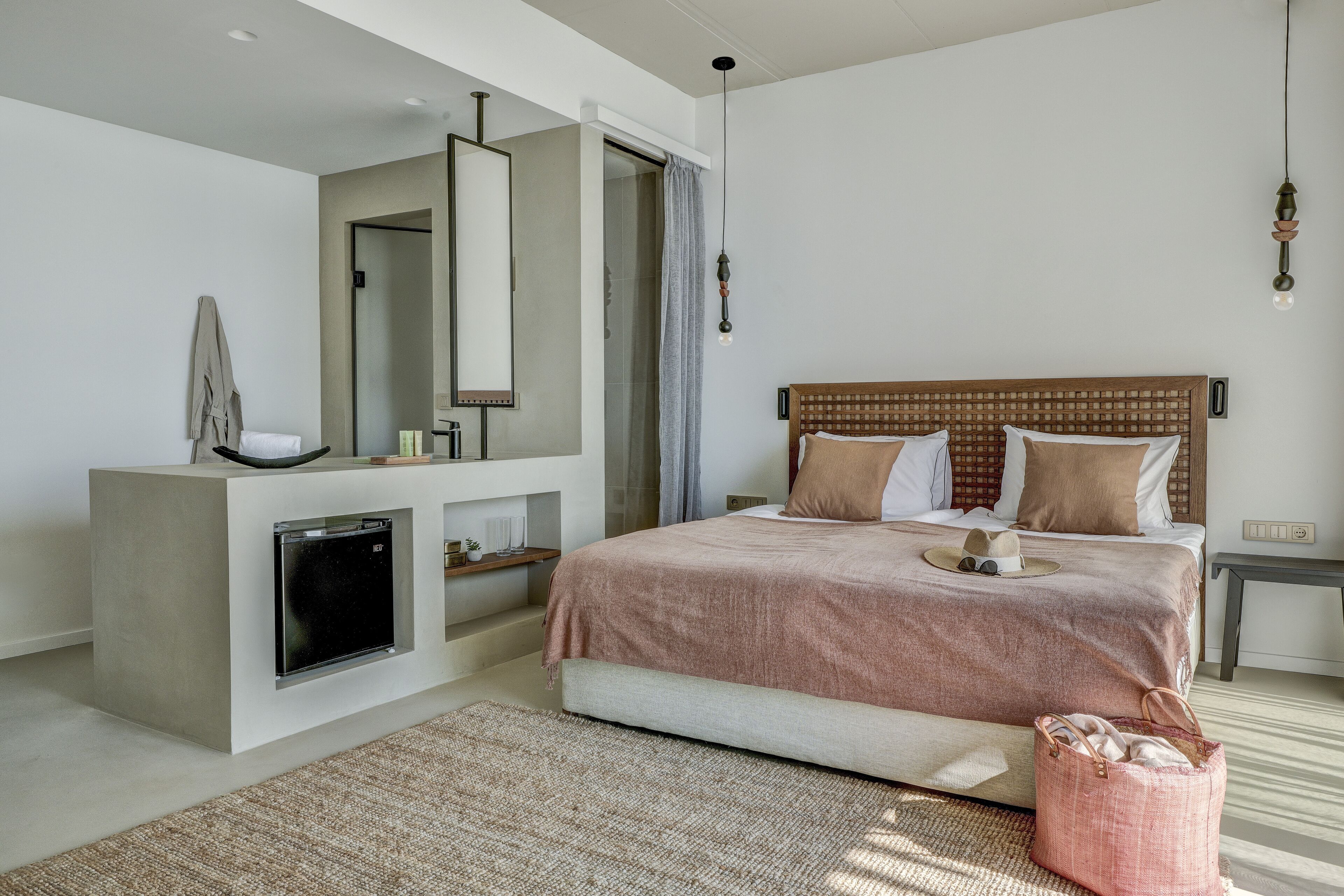 Un dormitorio moderno con una cama grande, un armario empotrado, una mesita de noche y una lámpara colgante.