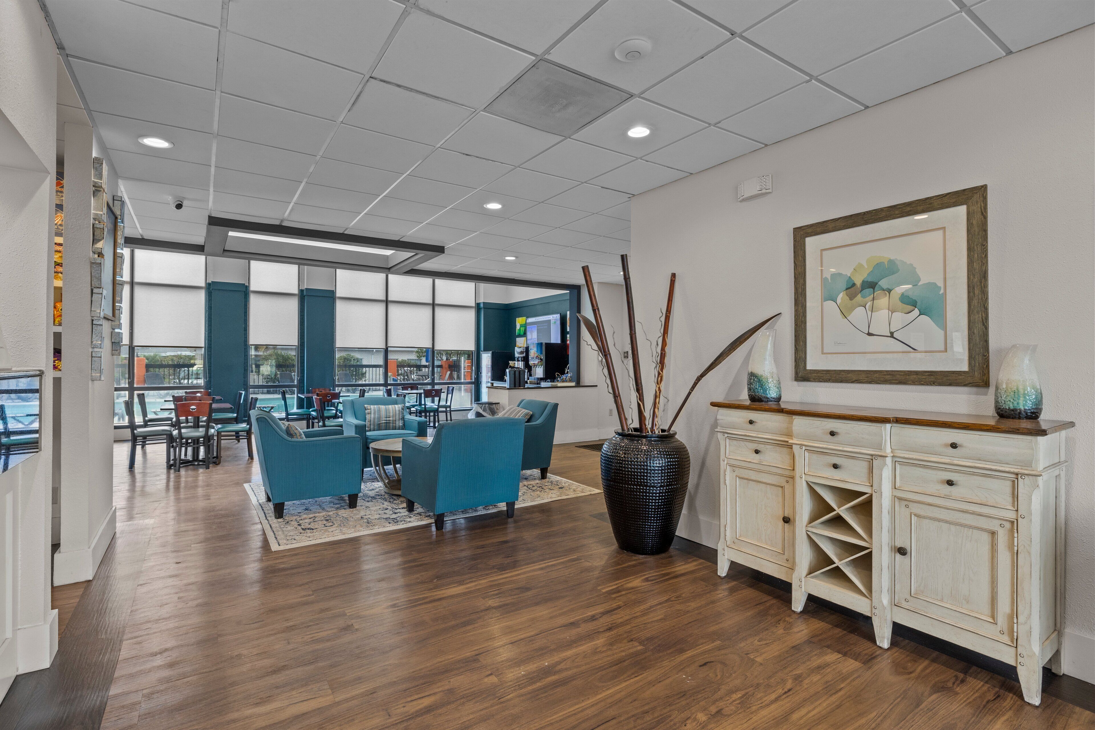 Un bureau spacieux au design moderne, doté d’un grand espace de réunion avec des chaises bleues et un plancher en bois.