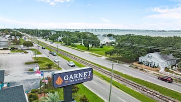 Straatbeeld met een bord voor Garnet Inn & Suites, een weg met auto's, een brug op de achtergrond en begroeiing.