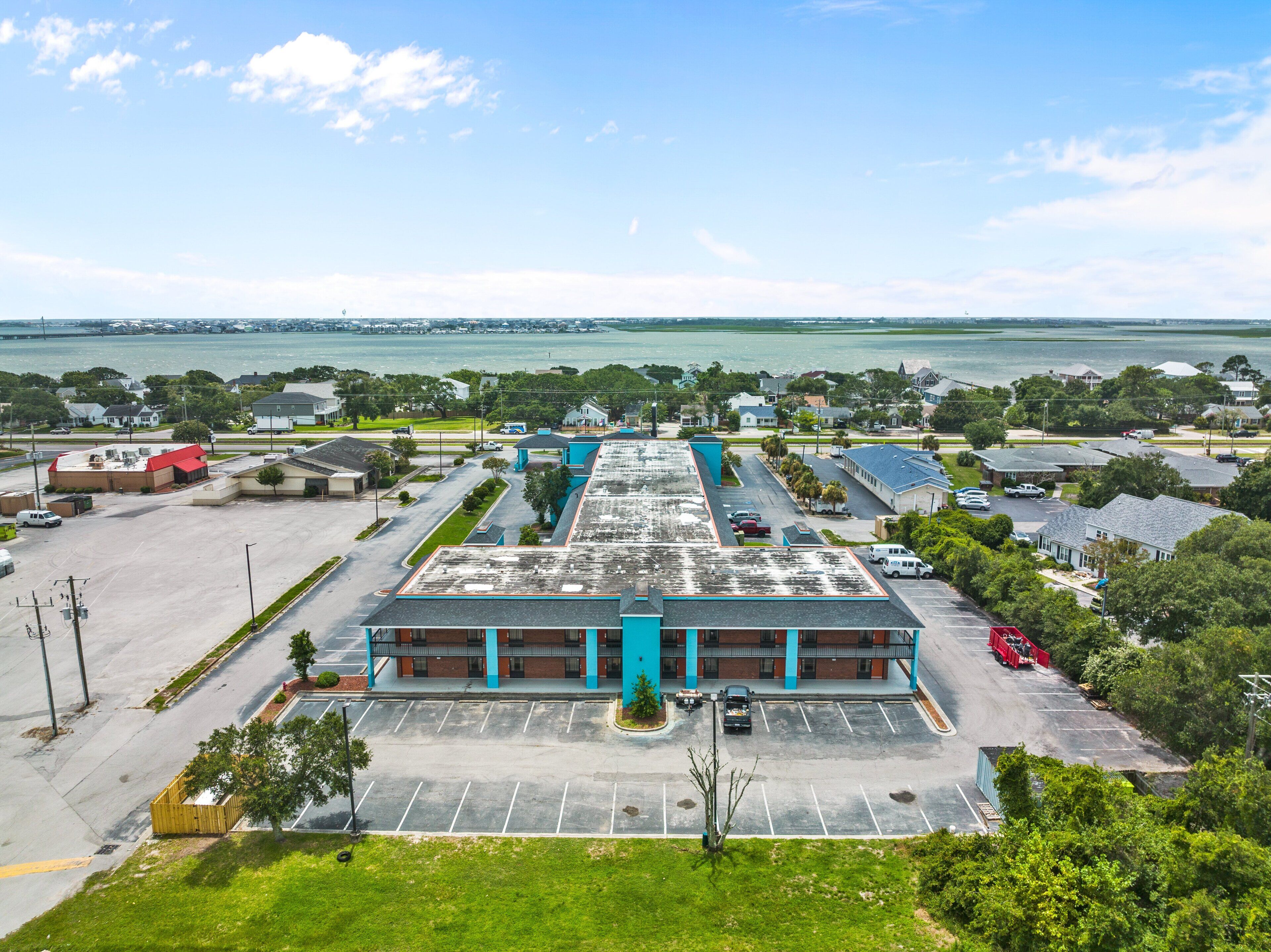 A large building with a parking lot and a view of the water.