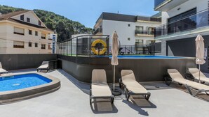 A rooftop pool area with lounge chairs, a pool, and a view of surrounding buildings. - Jessmart by Interhome (Lloret de Mar)