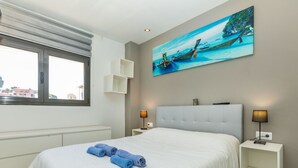 A modern hotel room with a large bed, two bedside tables, a window, and a painting of boats on the wall. - Jessmart by Interhome (Lloret de Mar)
