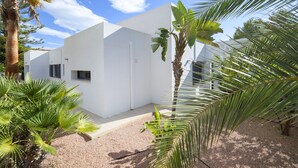 A modern white building with a flat roof, surrounded by palm trees and a gravel courtyard. - Bellveure by Interhome (Benissa)