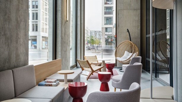 A modern interior with a sofa, chairs, and a hanging chair by a large window overlooking a cityscape. - URBAN LOFT Berlin (Berlin)