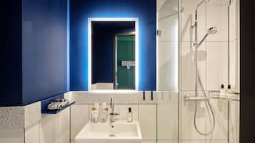 Ein modernes Badezimmer mit einem weißen Waschbecken, einem Spiegel und einer Dusche.