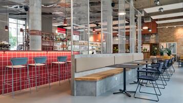 Een modern café met een bar, zitplaatsen en een open keuken.