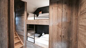 A bunk bed room with wooden walls and a staircase. - Chalet Keshi Collection Perles (BOLQUERE)