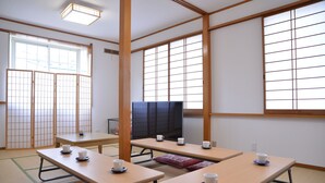 Et traditionelt japansk rum med tatamimåtter, shoji-skærme og lave borde med kopper.