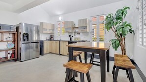 Et moderne køkken med en central ø, rustfrie apparater og træbarkstole.