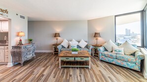 Een moderne woonkamer met een houten salontafel, een bloemenbank en twee bijzettafels met lampen.