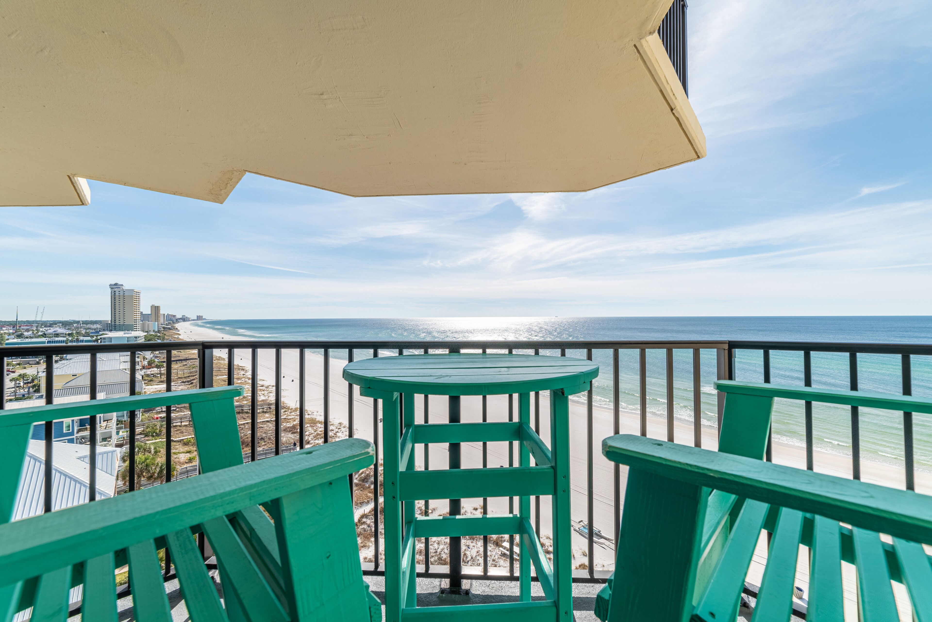 A balcony with a view of the beach and ocean.
