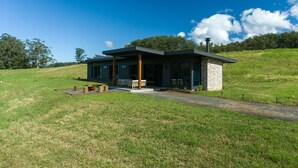 Une maison moderne dotée d’un patio, d’une petite terrasse et d’un chemin menant à l’entrée.