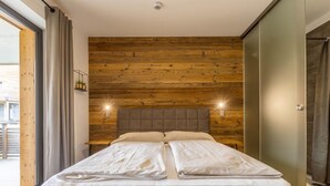 Un dormitorio moderno con una pared de madera, una cama grande y dos lámparas de noche.