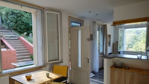 Cocina compacta con comedor, una escalera que da al exterior y vistas a zonas verdes.