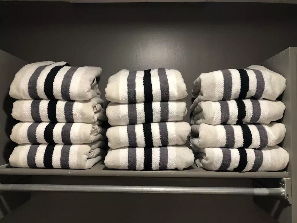 Um espaço de armazenamento com toalhas empilhadas de forma organizada e uniforme.