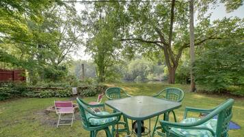 Relax in the garden with a view, surrounded by lush greenery and a wooden fence.