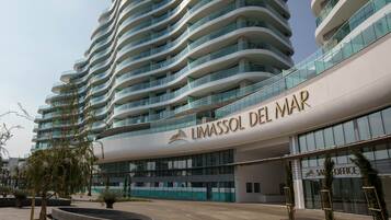 A modern hotel with a curved facade and multiple balconies.