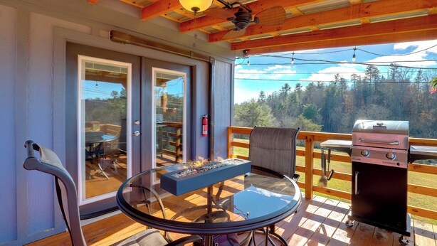 An outdoor deck with a glass table, chairs, a grill, and a view of a forest. - Pet-Friendly Studio w/ Hot Tub & Views in Marshall (Marshall)