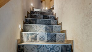 Uma escadaria com azulejos estampados e corrimãos de madeira.